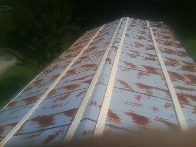 Rusted metal roof panels with new wood purlins before replacement — Storm Damage Roof Repair in Padroni by Roofing Brothers