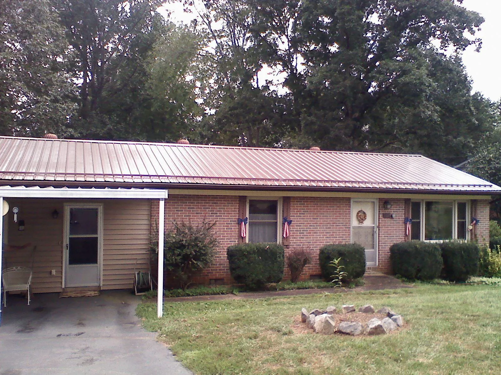 Bronze metal roof and carport on a brick ranch home — Roof Repair work by our crew in Padroni